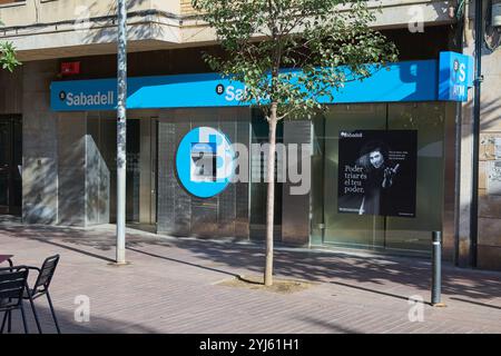 Montcada i Reixac. Spagna - 13 novembre 2024: Facciata della filiale della banca Sabadell con bancomat e marchio chiaro, situata in una strada pedonale Foto Stock