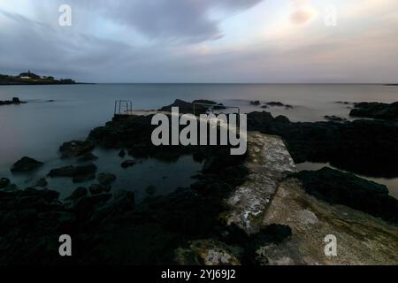 Il piccolo molo di Porto di Guilherme, Terceira, Azzorre, nonostante le sue dimensioni, è molto popolare tra i bagnanti nei mesi estivi. Foto Stock