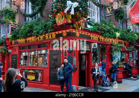 Dublino, Irlanda - 22 dicembre 2023: Turisti che scattano foto di fronte al famoso Temple Bar di Dublino Foto Stock