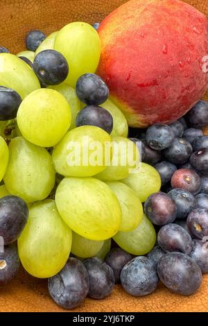 primo piano di frutta fresca, mirtilli, pesca e uva in un recipiente Foto Stock