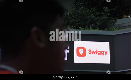 Mumbai, India. 13 novembre 2024. Il logo Swiggy è visibile su uno schermo LED all'interno della Borsa Nazionale (NSE) durante la cerimonia di quotazione. Credito: SOPA Images Limited/Alamy Live News Foto Stock