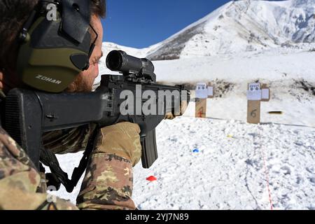 Un soldato dell'esercito italiano assegnato al 187° Reggimento paracadutisti "Folgore", ingaggia bersagli durante un'esercitazione di tiro all'interno del telaio Foto Stock