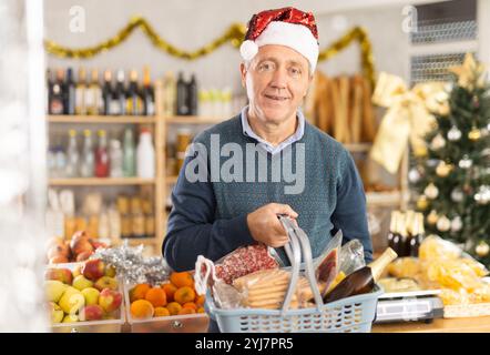 Uomo anziano con cestino di alimentari in negozio Foto Stock