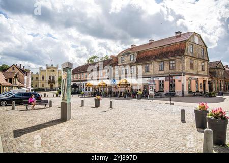 Kuldiga, Lettonia - 3 luglio 2023: Piazza del Municipio, via Baznicas, con ristoranti e strade acciottolate. Foto Stock