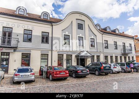 Kuldiga, Lettonia - 3 luglio 2023: Piazza del Municipio, via Baznicas, con ristoranti Metrapole e strada acciottolata in pietra. Foto Stock