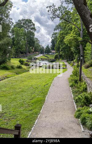 Kuldiga, Lettonia - 3 luglio 2023: Parco con giardino cittadino di Kuldiga con laghetto e fontane. Foto Stock