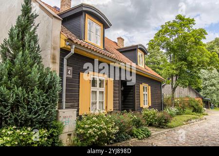 Kuldiga, Lettonia - 3 luglio 2023: Una vecchia casa storica in legno marrone giallo. Foto Stock