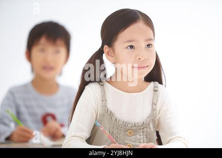 Alunni di scuola elementare inferiore maschili e femminili in classe Foto Stock