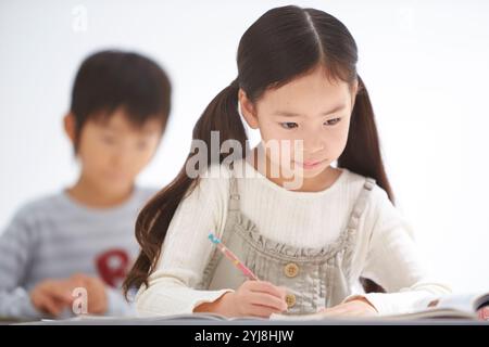 Alunni di scuola elementare inferiore maschili e femminili in classe Foto Stock