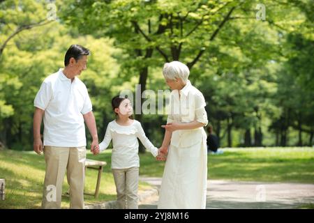 Coppia di anziani e nipoti che camminano nel parco Foto Stock