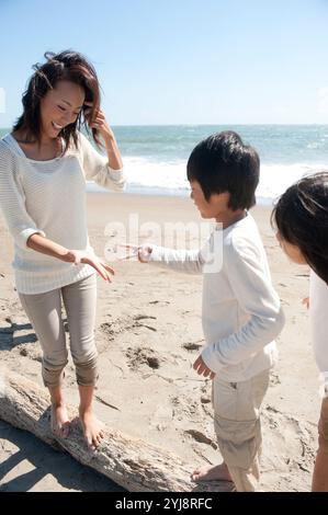 Madre e figlio che giocano a forbici da carta rock sul mare Foto Stock