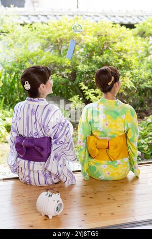 Madre e figlia in yukata sulla veranda, vista posteriore Foto Stock