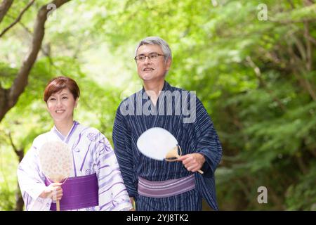 Verde fresco e una coppia di mezza età in yukata Foto Stock