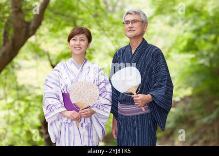 Verde fresco e una coppia di mezza età in yukata Foto Stock