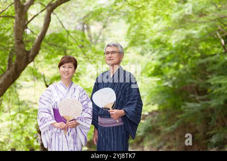 Verde fresco e una coppia di mezza età in yukata Foto Stock