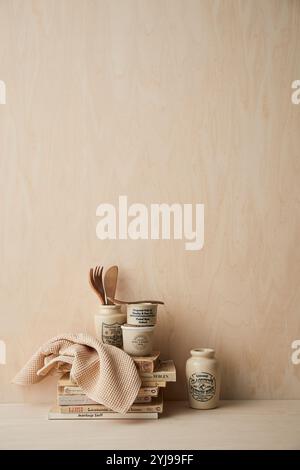 Libri, stracci e utensili da cucina in tonalità beige Foto Stock