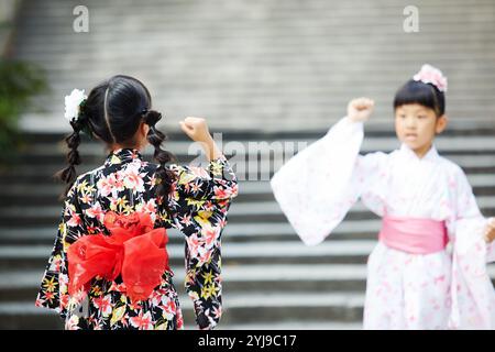 Ragazza nello yukata che gioca a forbici da carta rock Foto Stock