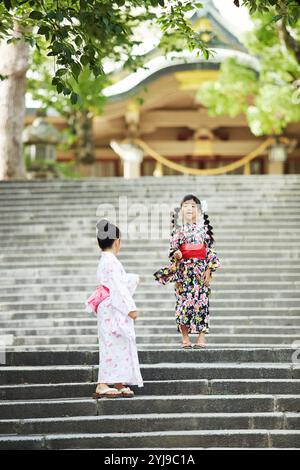 Due ragazze nello yukata che giocano sulle scale Foto Stock