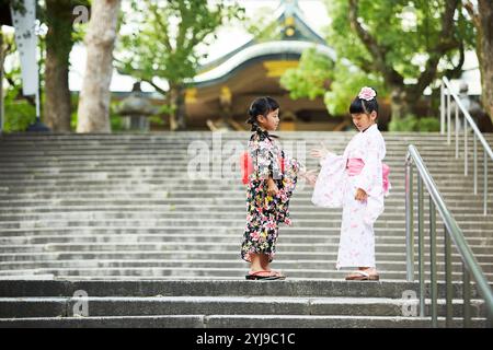 Ragazza nello yukata che gioca a forbici da carta rock Foto Stock