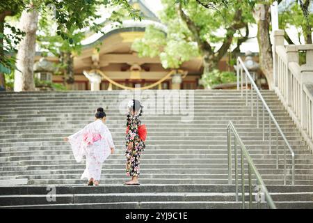 Due ragazze nello yukata che giocano sulle scale Foto Stock