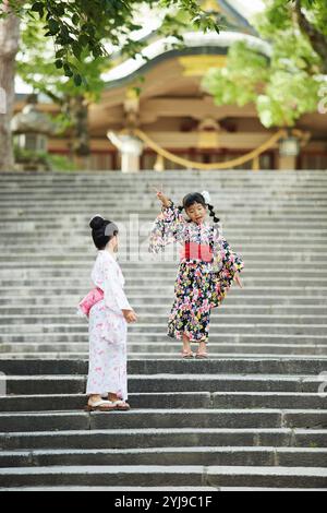 Due ragazze nello yukata che giocano sulle scale Foto Stock