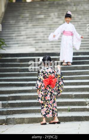 Due ragazze nello yukata che giocano sulle scale Foto Stock