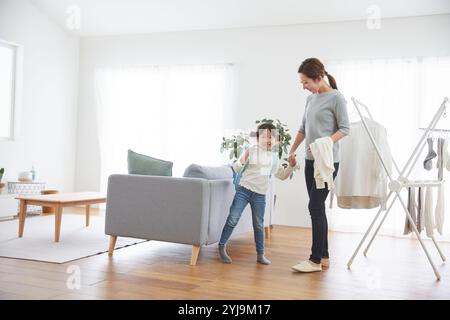 Bambino e madre si preparano per la scuola in salotto Foto Stock