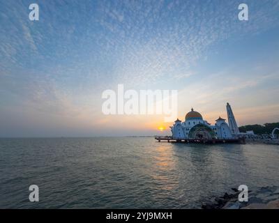 Moschea dello stretto di Malacca al tramonto. Questa moschea si trova sull'isola di Malacca nella storica città di Malacca, Malesia. Città storiche dello stretto di Malac Foto Stock