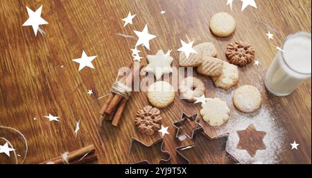 Immagine di stelle che cadono sopra i biscotti di natale sul tavolo. Natale e festeggiamenti, immagine generata digitalmente. Foto Stock