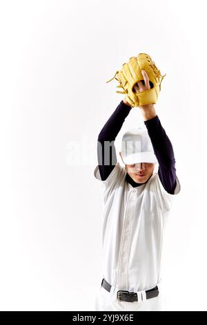 Uomo in uniforme da baseball che cerca di lanciare palla Foto Stock