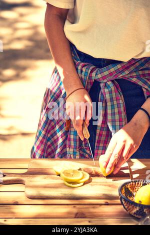 Donna che taglia limoni in campo Foto Stock