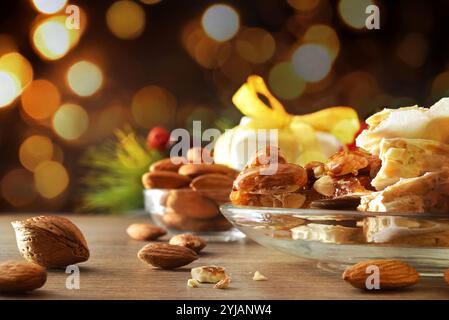 Piatto con pezzi di torrone appena preparato con decorazione e atmosfera natalizia. Vista frontale. Foto Stock