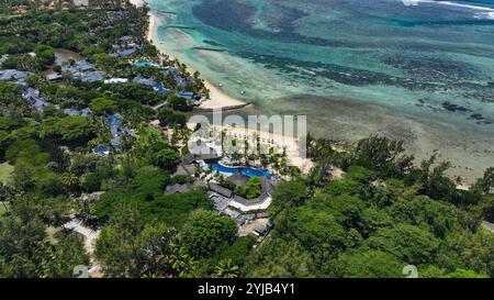 Una vista dall'alto di un resort situato su una spiaggia panoramica a Mauritius, che mostra i suoi servizi, la piscina e il paesaggio tropicale circostante. Foto Stock