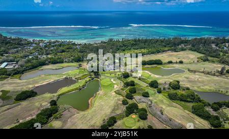 Una fotografia aerea che mostra un campo da golf situato a Mauritius, adiacente all'oceano, catturando il paesaggio mozzafiato e la disposizione del campo. Foto Stock