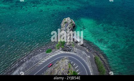 Una foto aerea che cattura una strada che si snoda lungo il maestoso oceano di Mauritius. Foto Stock