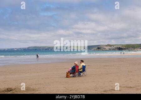 Due vacanzieri seduti sulle sedie del GT Western Great Western Beach durante la bassa marea sulla costa di Newquay in Cornovaglia nel Regno Unito. Foto Stock