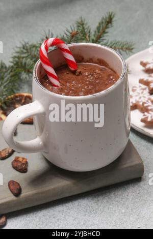 Accogliente concetto di stile di vita invernale. Tazza di bevanda calda con libro vintage e gustosi biscotti natalizi al pan di zenzero fatti in casa. Foto Stock