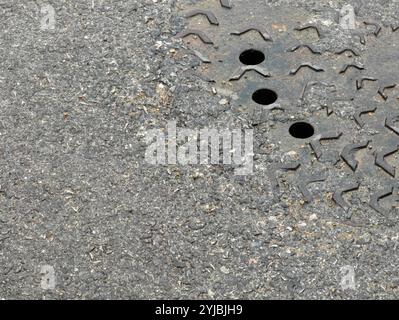 Rainy Street Infrastructure: Tombino con tre fori di drenaggio Foto Stock