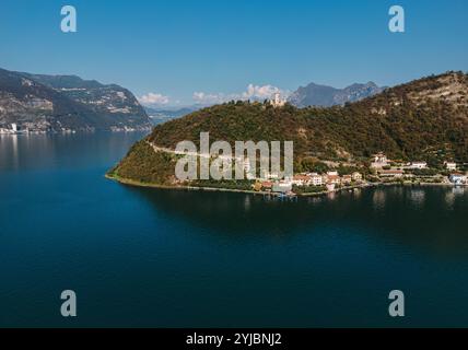 Vista aerea di un tranquillo lago circondato da colline lussureggianti e piccoli villaggi costieri, catturando la bellezza della natura e la tranquillità in un pittoresco Foto Stock