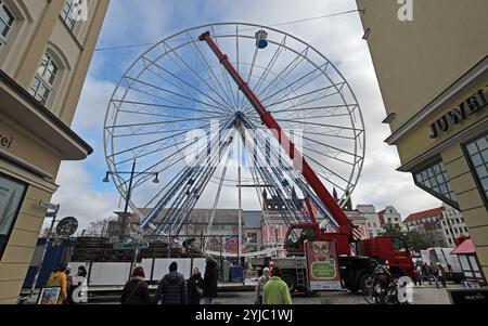 Rostock, Germania. 14 novembre 2024. Le prime bancarelle del mercato di Natale sono allestite a Neuer Markt, la ruota panoramica ha la sua prima funivia. Il mercato di Natale di Rostock è considerato il più grande della Germania settentrionale e apre dal 25.11. Al 22.12.2024. Crediti: Bernd Wüstneck/dpa/Alamy Live News Foto Stock