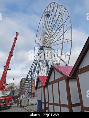 Rostock, Germania. 14 novembre 2024. Le prime bancarelle del mercato di Natale sono allestite a Neuer Markt, la ruota panoramica ha la sua prima funivia. Il mercato di Natale di Rostock è considerato il più grande della Germania settentrionale e apre dal 25.11. Al 22.12.2024. Crediti: Bernd Wüstneck/dpa/Alamy Live News Foto Stock