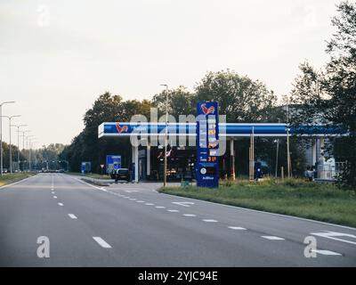 Texel, Paesi Bassi - 29 agosto 2024: Stazione di servizio Haan situata lungo una tranquilla strada olandese nei Paesi Bassi. I prezzi del carburante sono visibili sul cartello e l'ambientazione riflette una serata tranquilla con luce soffusa e una strada per lo più vuota Foto Stock