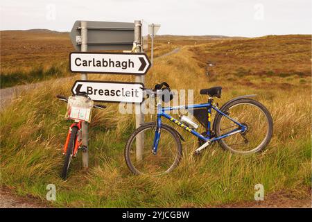 Due bici da strada con un cartello stradale su Phentland Road, Isle of Lewis, Scotland UK, che mostra il desolato e selvaggio paesaggio a ovest di Stornoway. Foto Stock