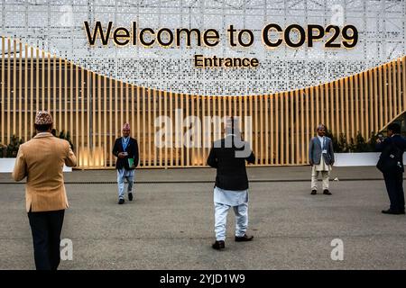 Baku, Azerbaigian, 13 novembre 2024. I partecipanti scattano foto di fronte a un ingresso principale durante la conferenza delle Nazioni Unite sui cambiamenti climatici COP29, un evento organizzato dall'UNFCCC allo stadio Olimpico di Baku. La COP29, in vigore dal novembre 11-22, si concentra sui mercati del carbonio e sui finanziamenti per la sostenibilità e la mitigazione. Crediti: Dominika Zarzycka/Alamy Live News. Foto Stock