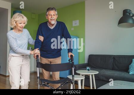 Donna anziana che aiuta un anziano a entrare nell'appartamento a casa. Foto Stock