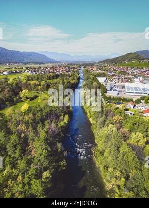 Vista aerea, drone che sorvola la comunità suburbana in campagna. Case di famiglia nei sobborghi circondate da boschi e campi verdi Foto Stock