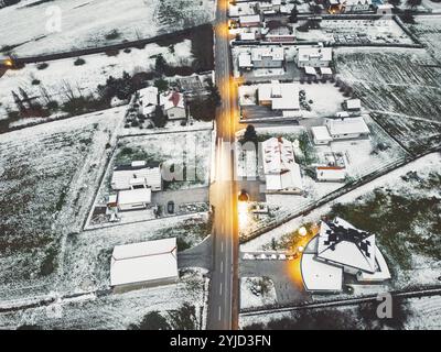 Vista aerea della comunità suburbana in inverno la sera. Neve sul terreno, buio, luci stradali brillanti Foto Stock