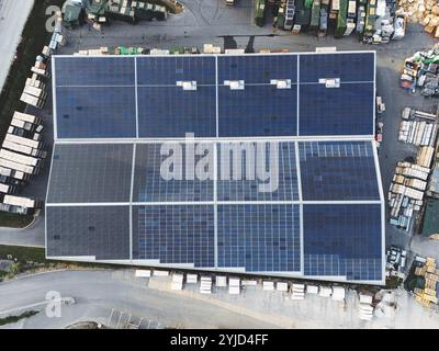 Veduta aerea di una fabbrica e di un magazzino nei sobborghi con tetto coperto da pannelli solari. Foto Stock