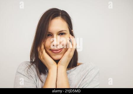 Bella giovane donna che pulisce il viso, rimuovendo il trucco con un panno di cotone e acqua micellare. Cura e bellezza della pelle. Giovane bella donna che pulisce h Foto Stock