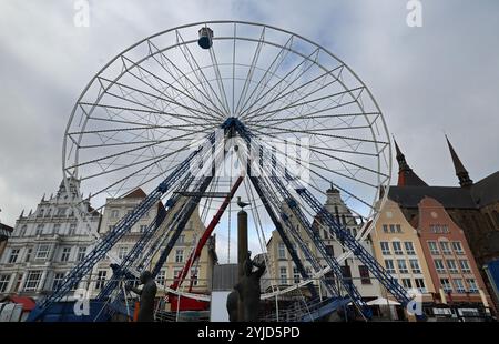 Rostock, Germania. 14 novembre 2024. Sul Neuer Markt sono allestite le prime bancarelle di Natale e la ruota panoramica ha la sua prima funivia. Il mercato di Natale di Rostock è considerato il più grande della Germania settentrionale e apre dal 25.11. Al 22.12.2024. Crediti: Bernd Wüstneck/dpa/Alamy Live News Foto Stock